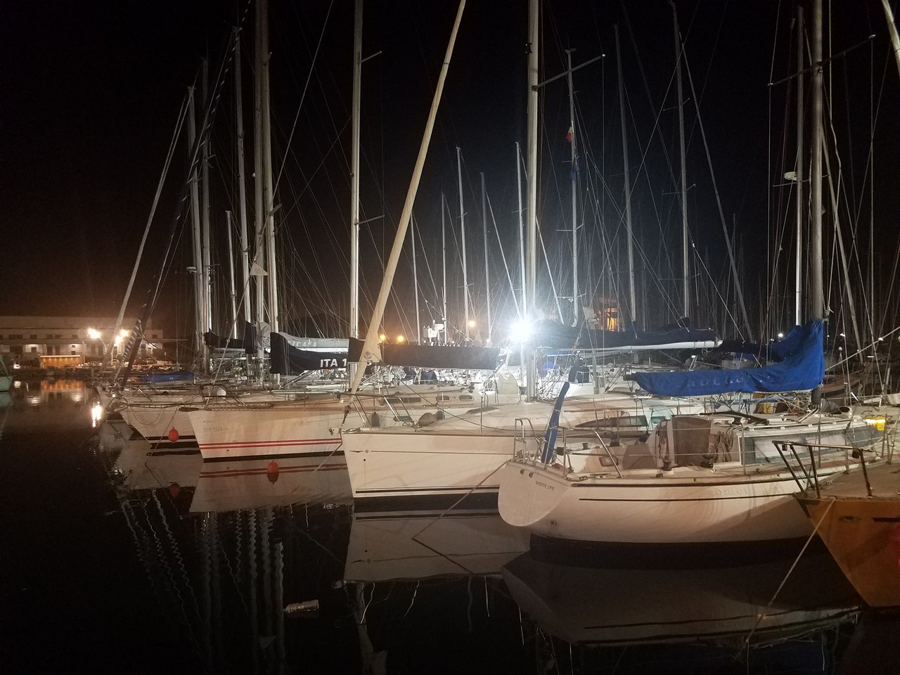 a group of boats on water at night