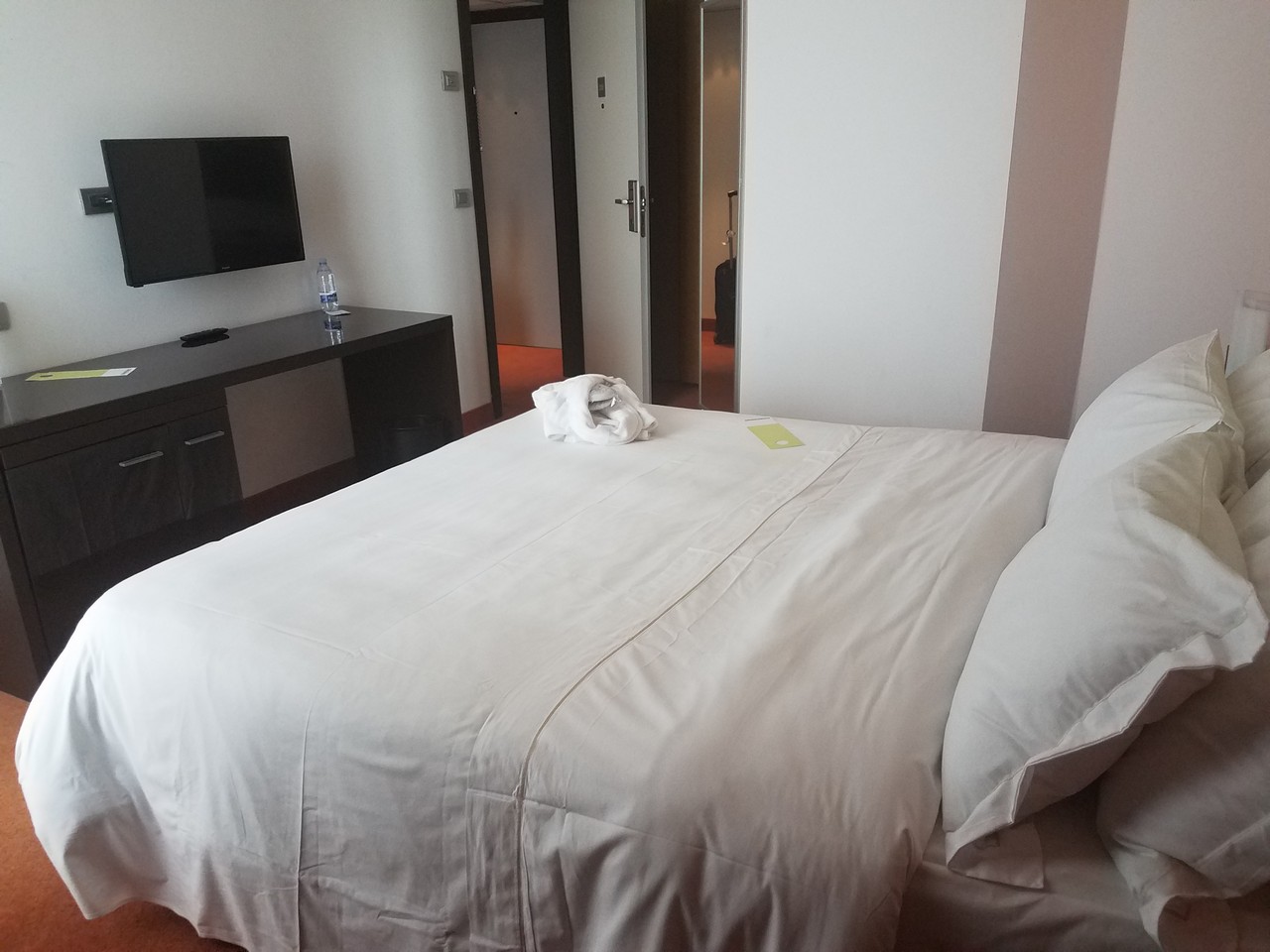 a bed with a white sheet and a tv