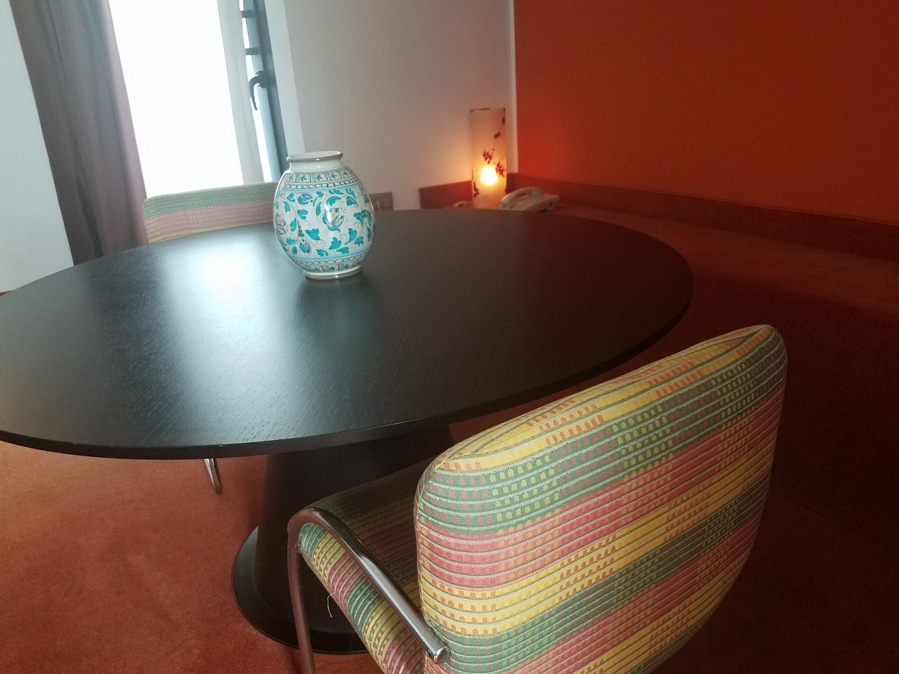 a table with chairs and a vase on it