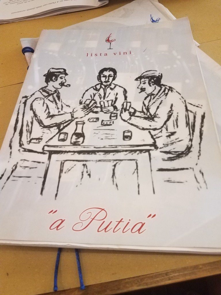 a menu with a drawing of men sitting at a table