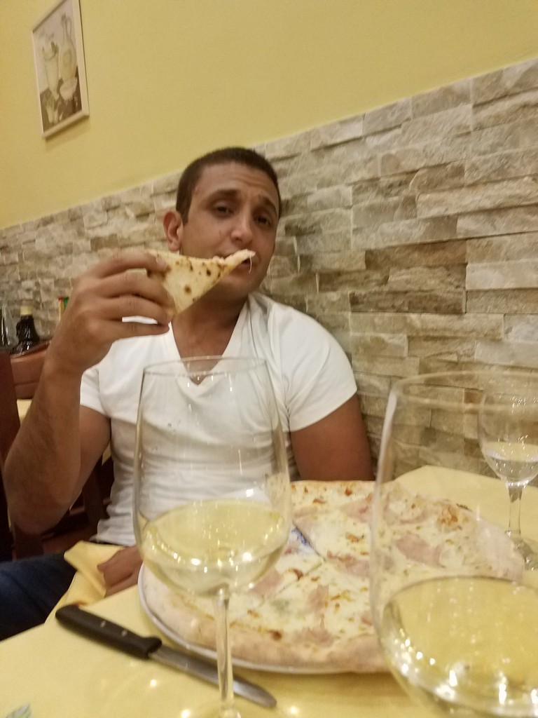 a man eating pizza at a restaurant