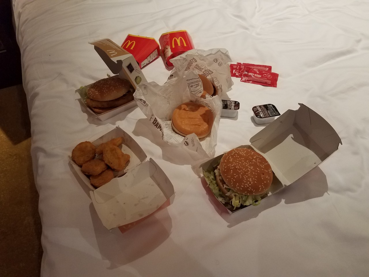 a group of fast food boxes on a bed