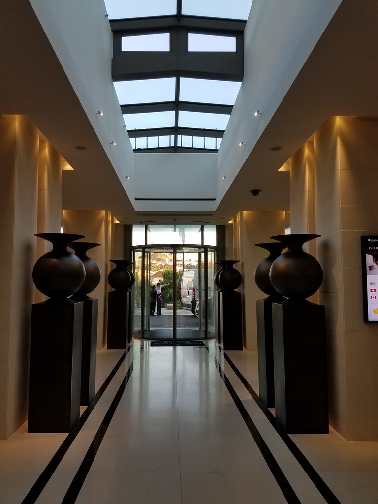 a hallway with large vases and a glass door
