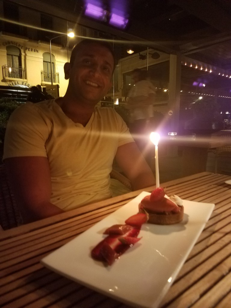 a man sitting at a table with a lit candle on a plate