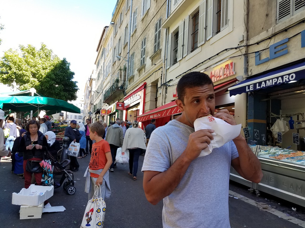 a man eating a sandwich on a street