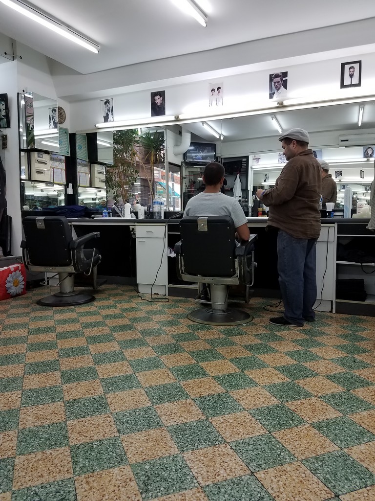 a man standing in front of a counter in a barber shop