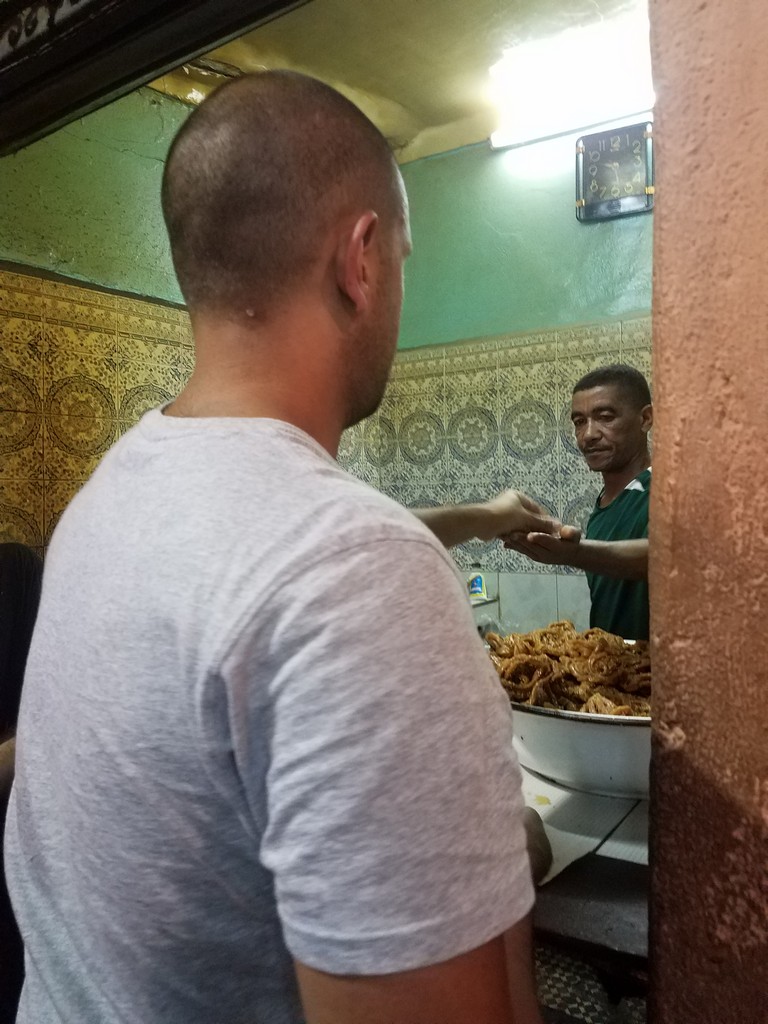 a man handing food to another man