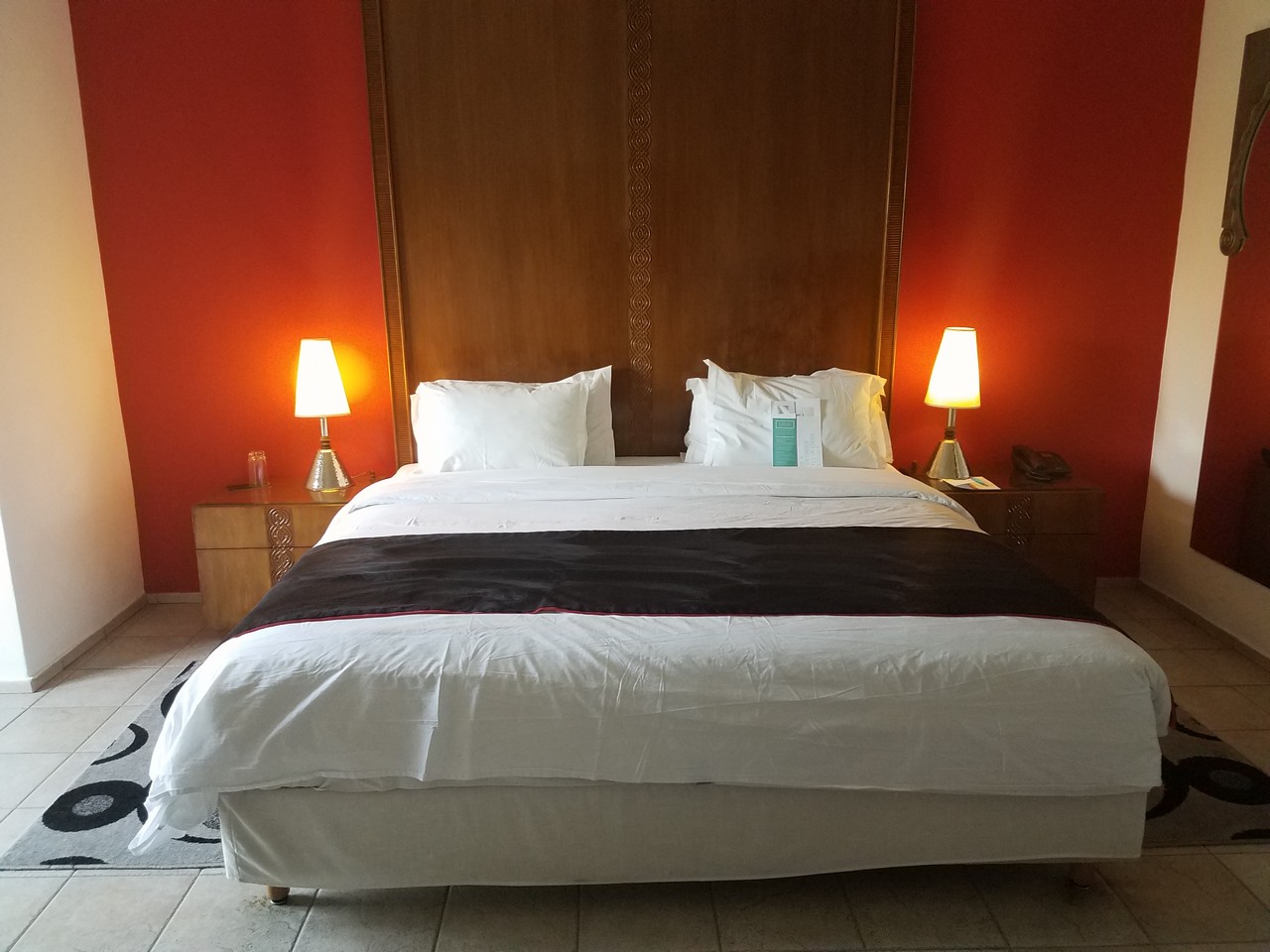 a bed with a wood headboard and lamps