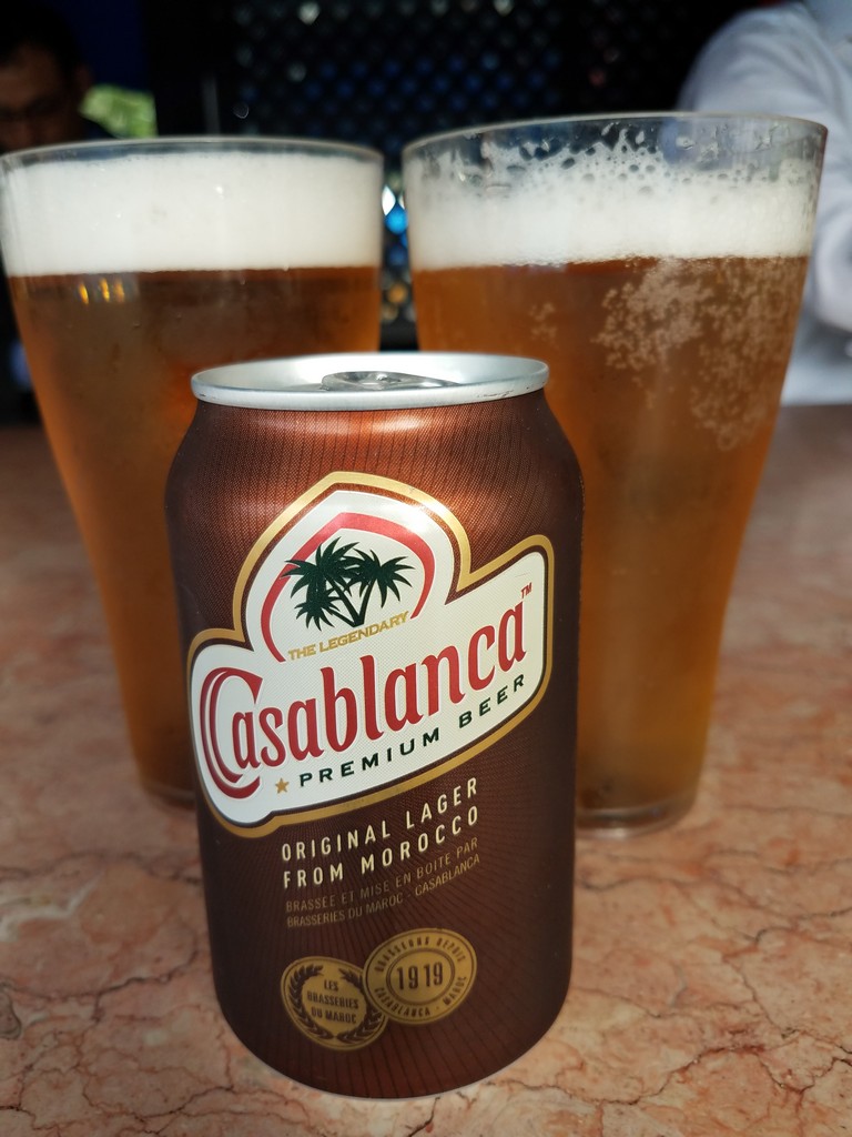 a can of beer next to glasses of beer