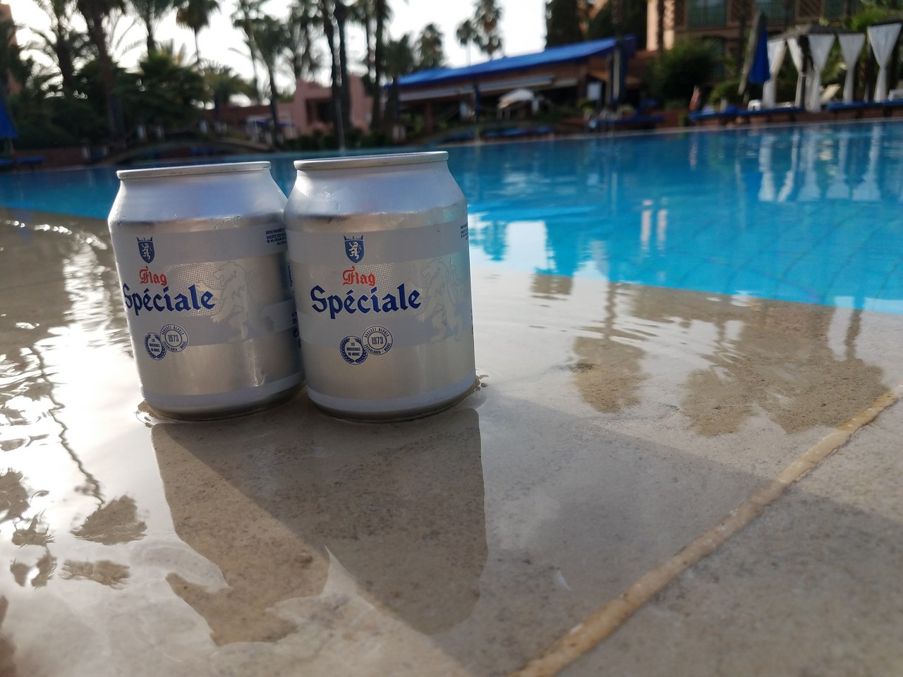 two cans of beer on a pool side