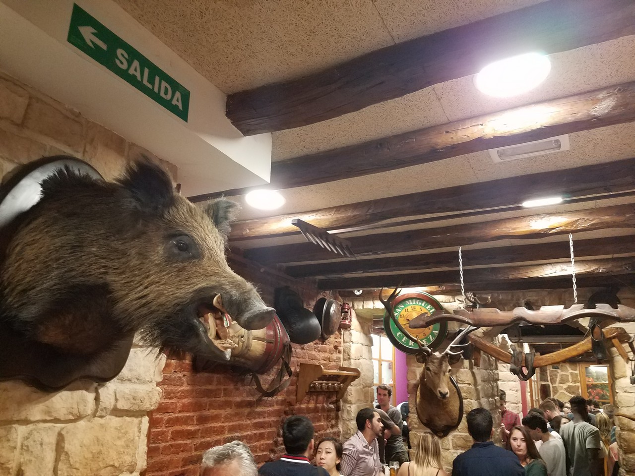 a group of people in a room with a fake boar head