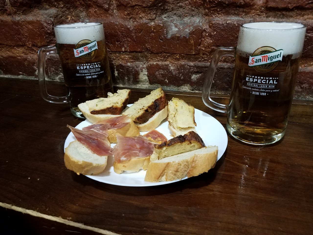 a plate of food and two mugs of beer on a table