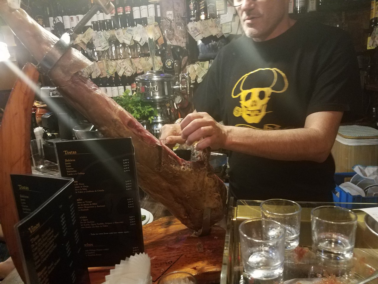 a man cutting meat in a bar