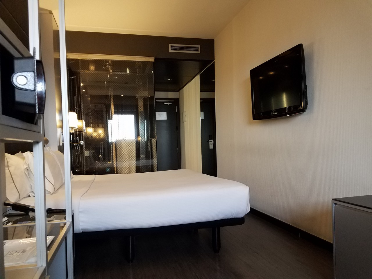 a room with a bed and a television on the wall