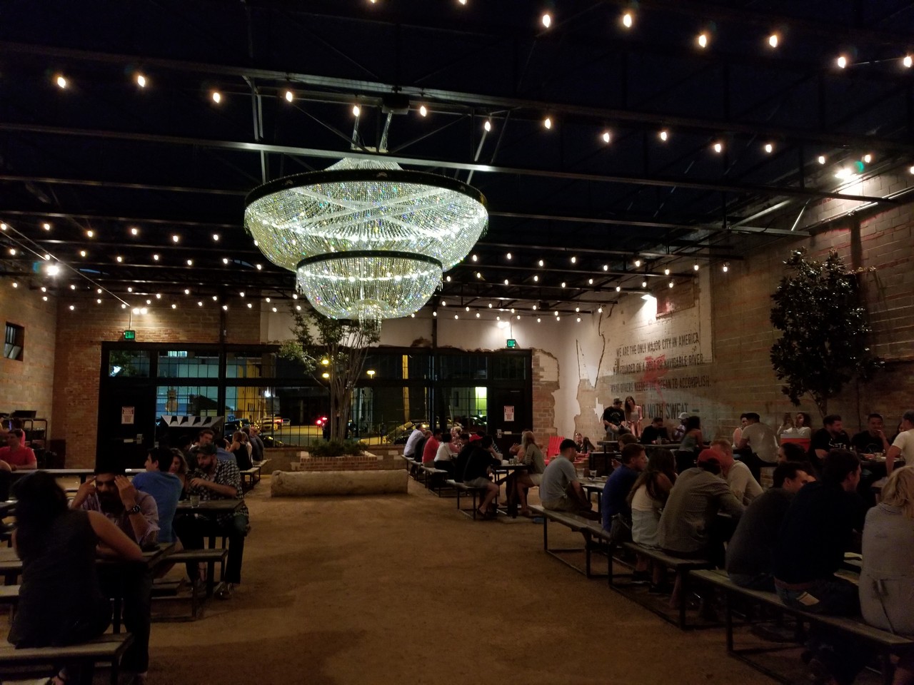 a group of people sitting in benches and a chandelier
