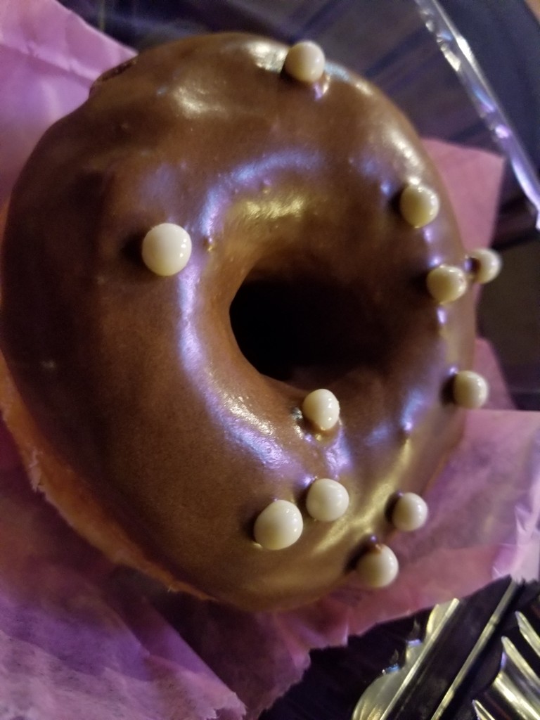 a chocolate donut with white dots on it
