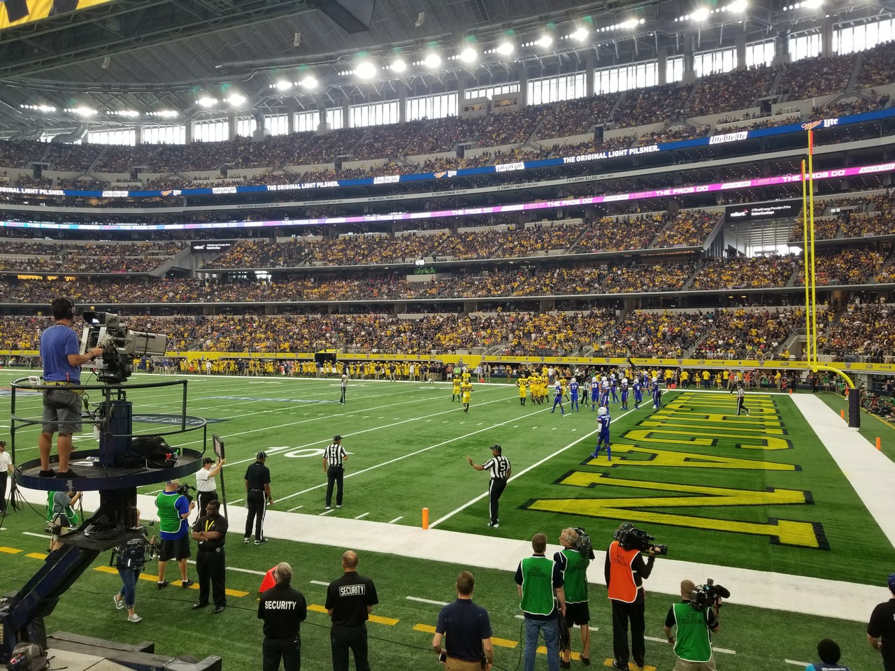 a football game in a stadium with AT&T Stadium in the background