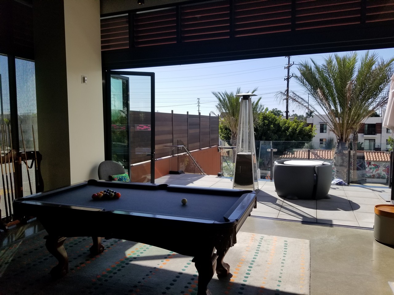 a pool table in a room with glass doors