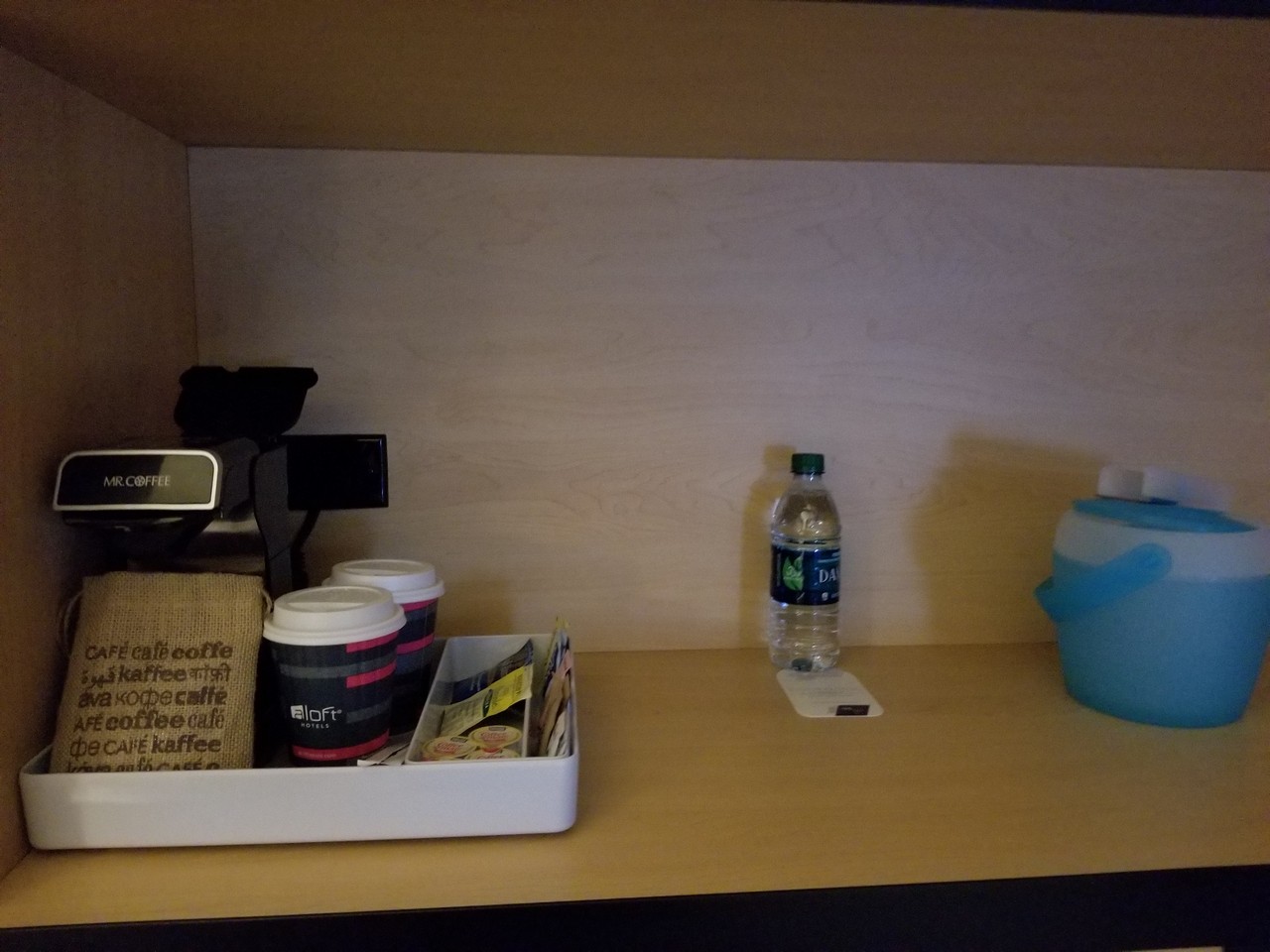 a shelf with coffee cups and a water bottle