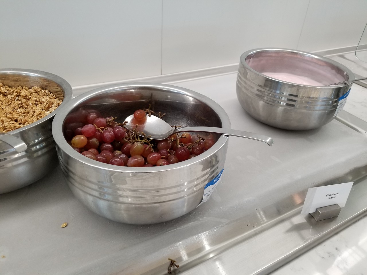 a bowl of grapes with a spoon in it