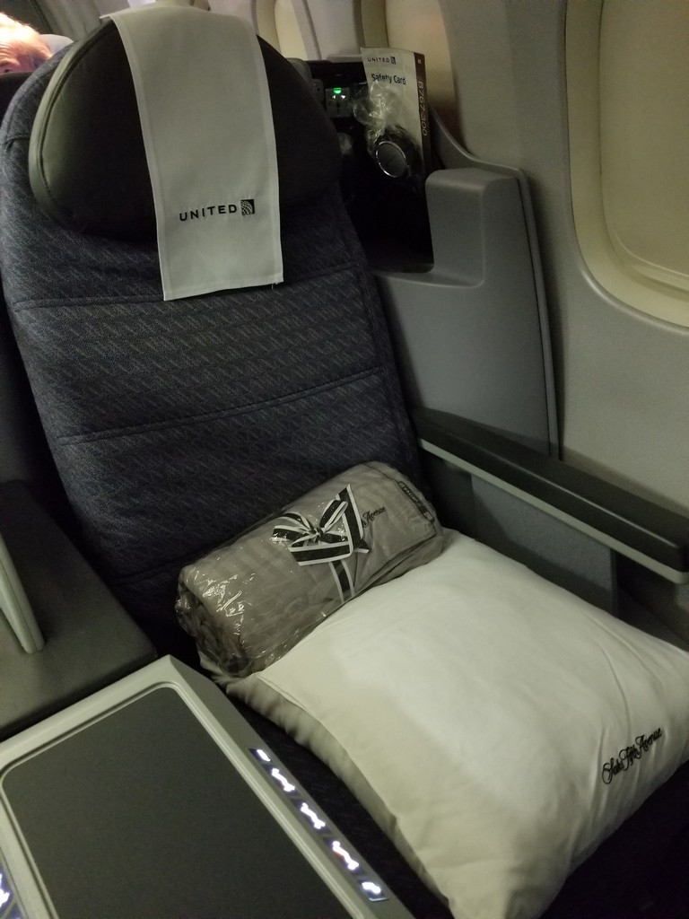 a seat with a pillow and a blanket on it