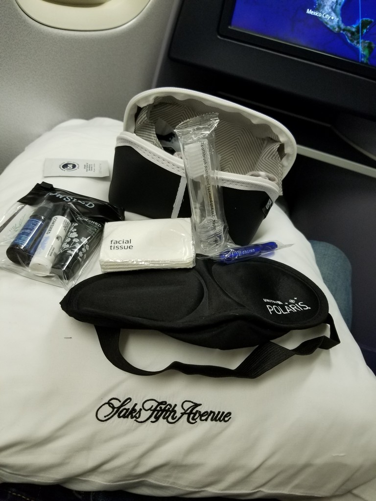 a bag with a black strap and a white bag with a black strap and a black eye mask