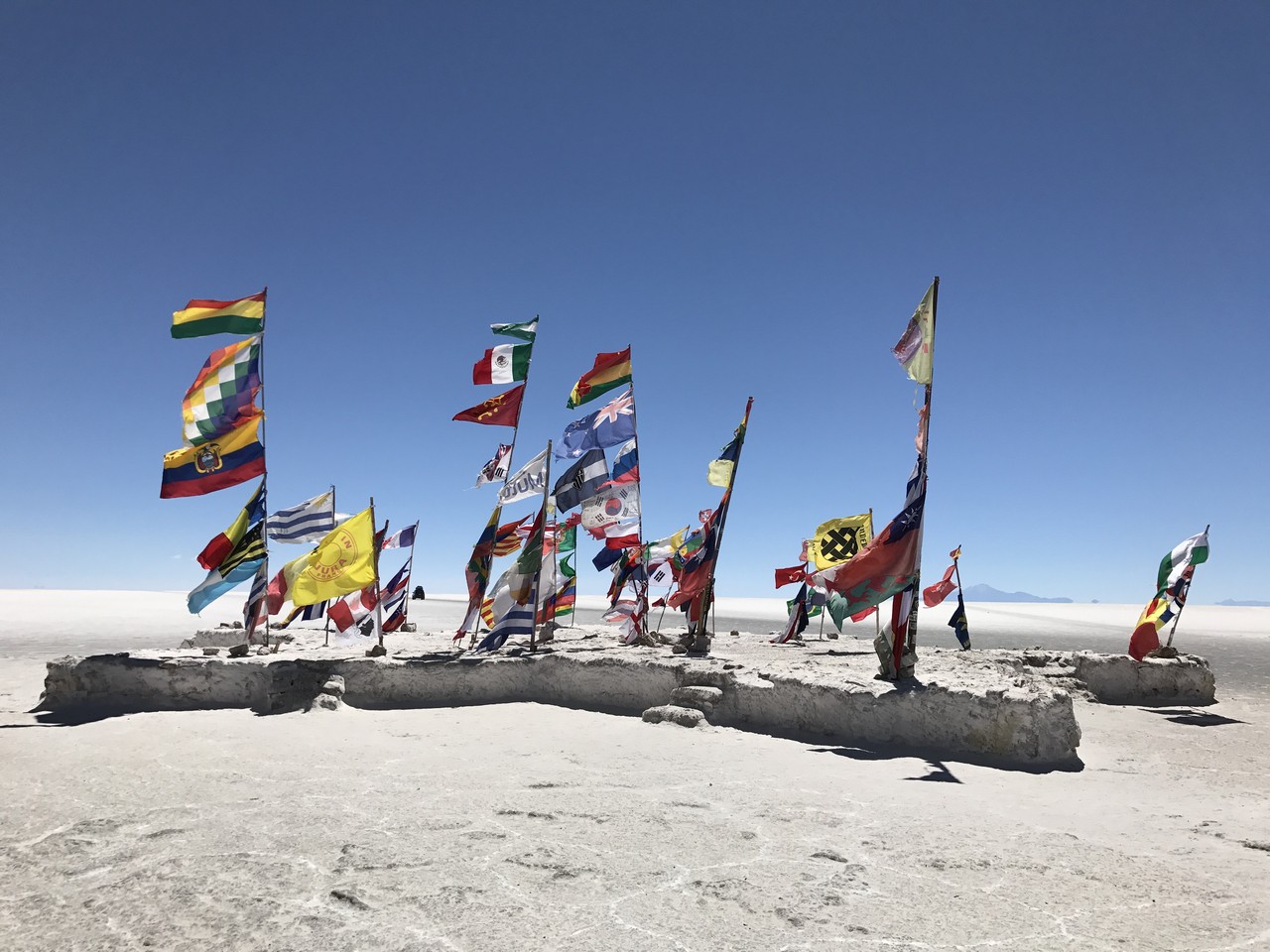 a group of flags on a sandy area