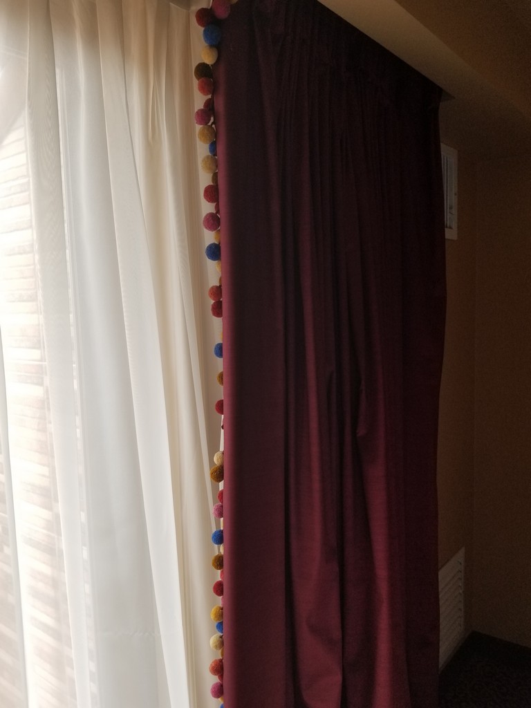 a curtain with pom poms