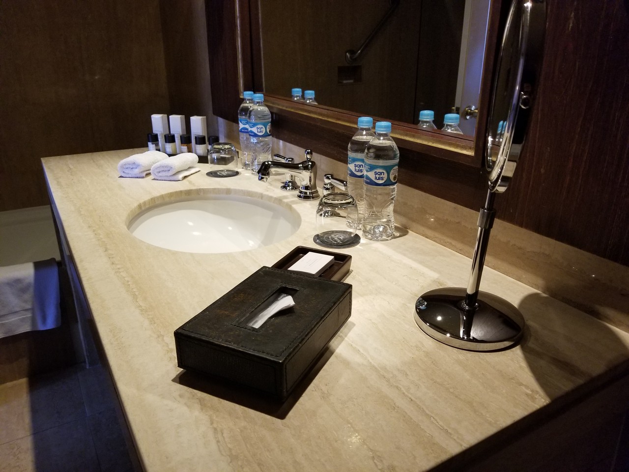 a bathroom sink with a mirror and a box of tissues
