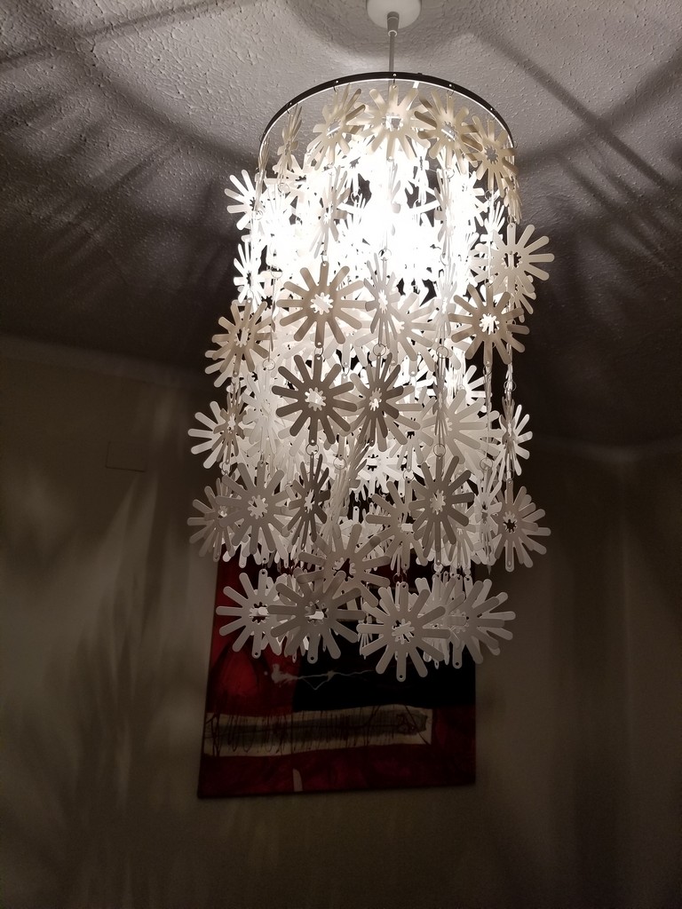 a light fixture with white flowers