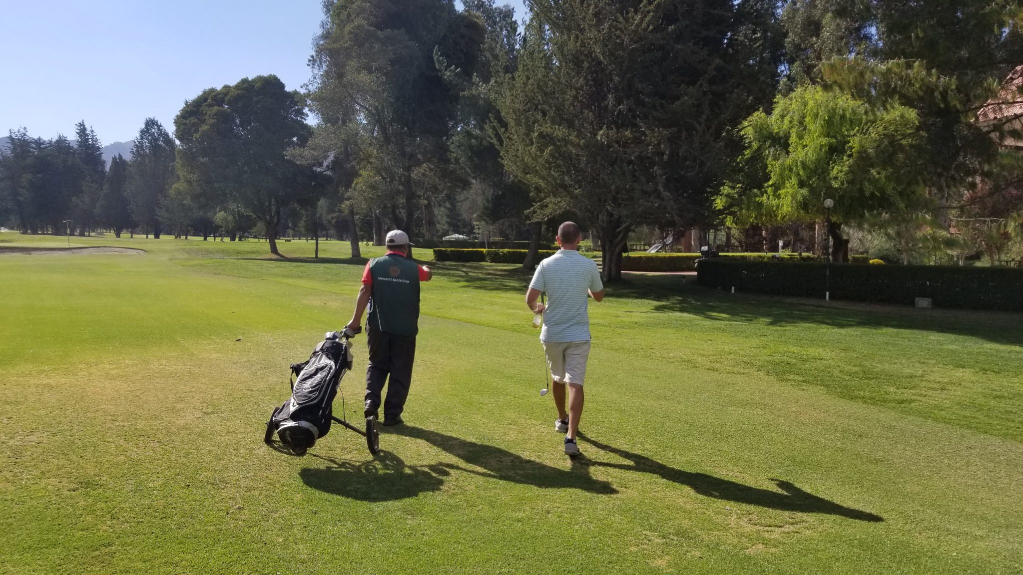 a group of men walking on a golf course