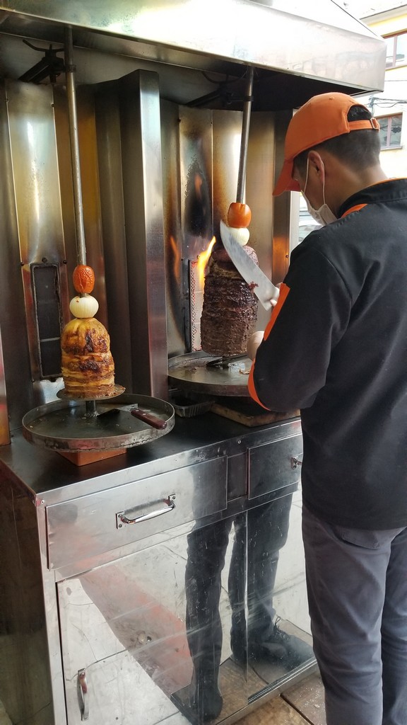 a man cutting meat on a large machine