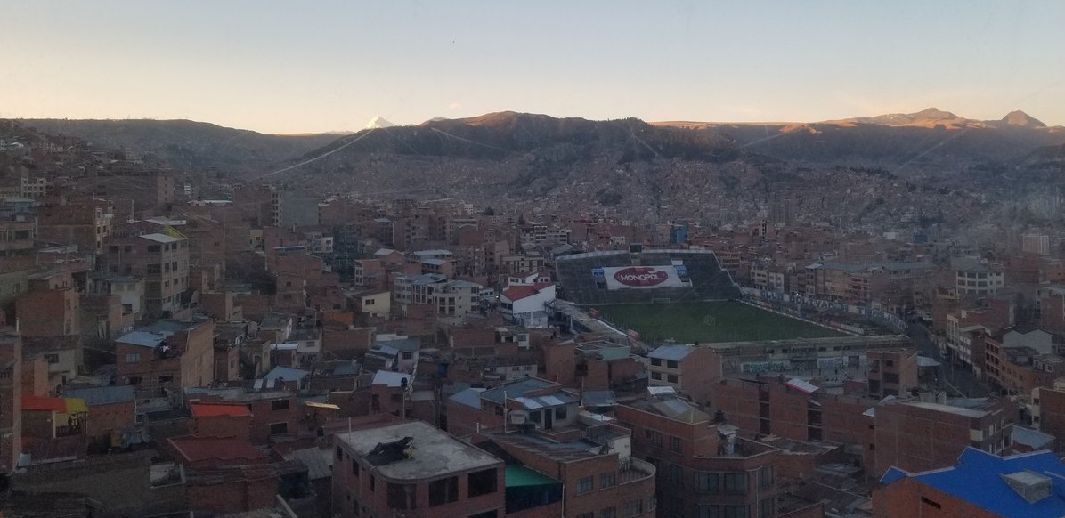 a city with a large stadium and a mountain in the background
