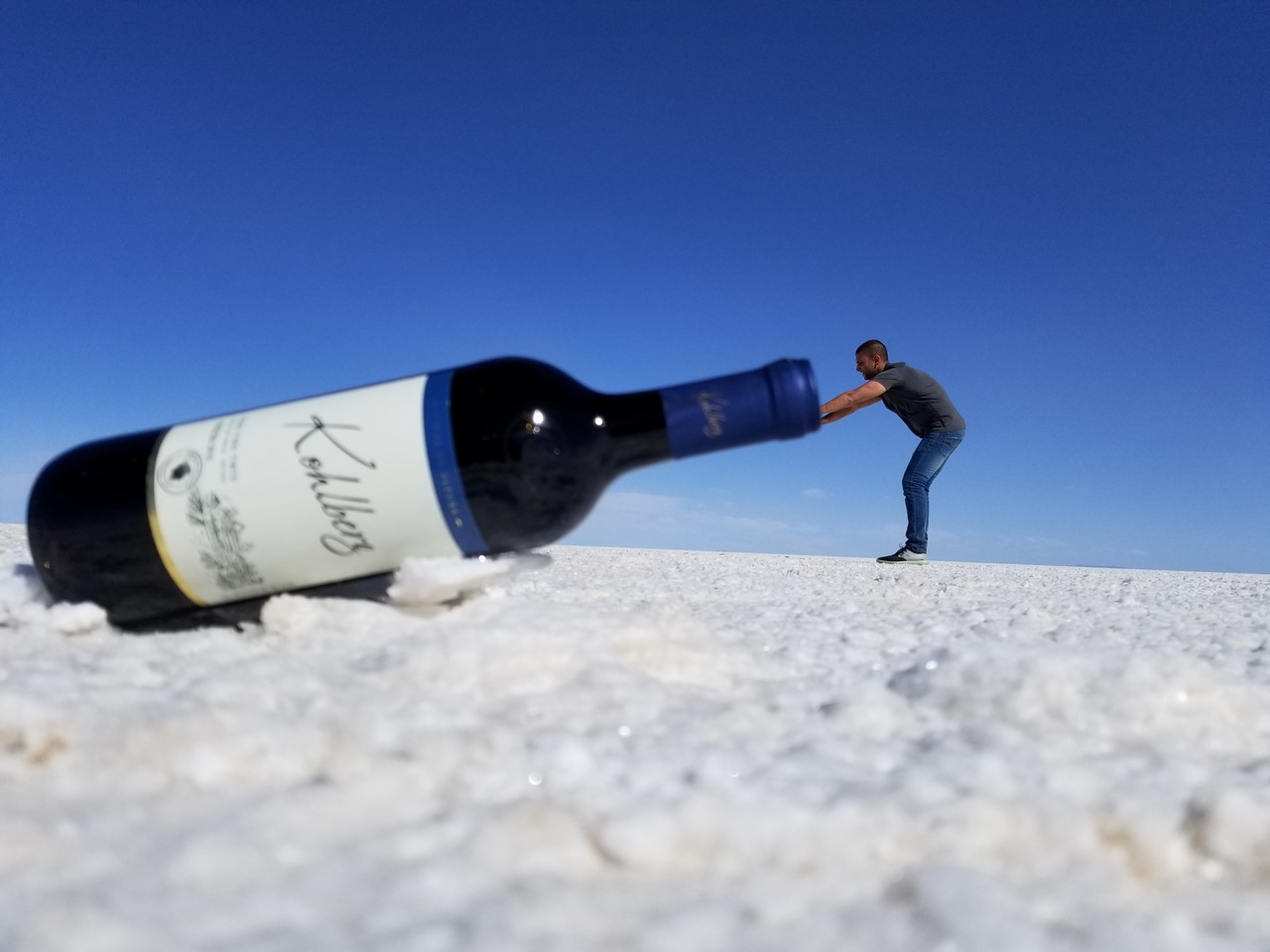a man pushing a bottle of wine