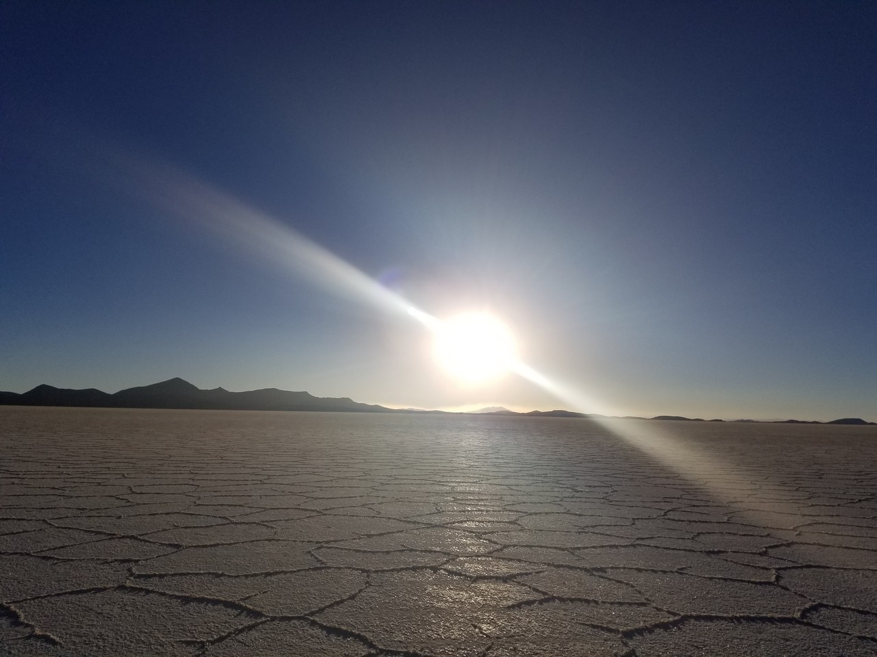 a sun shining over a flat desert