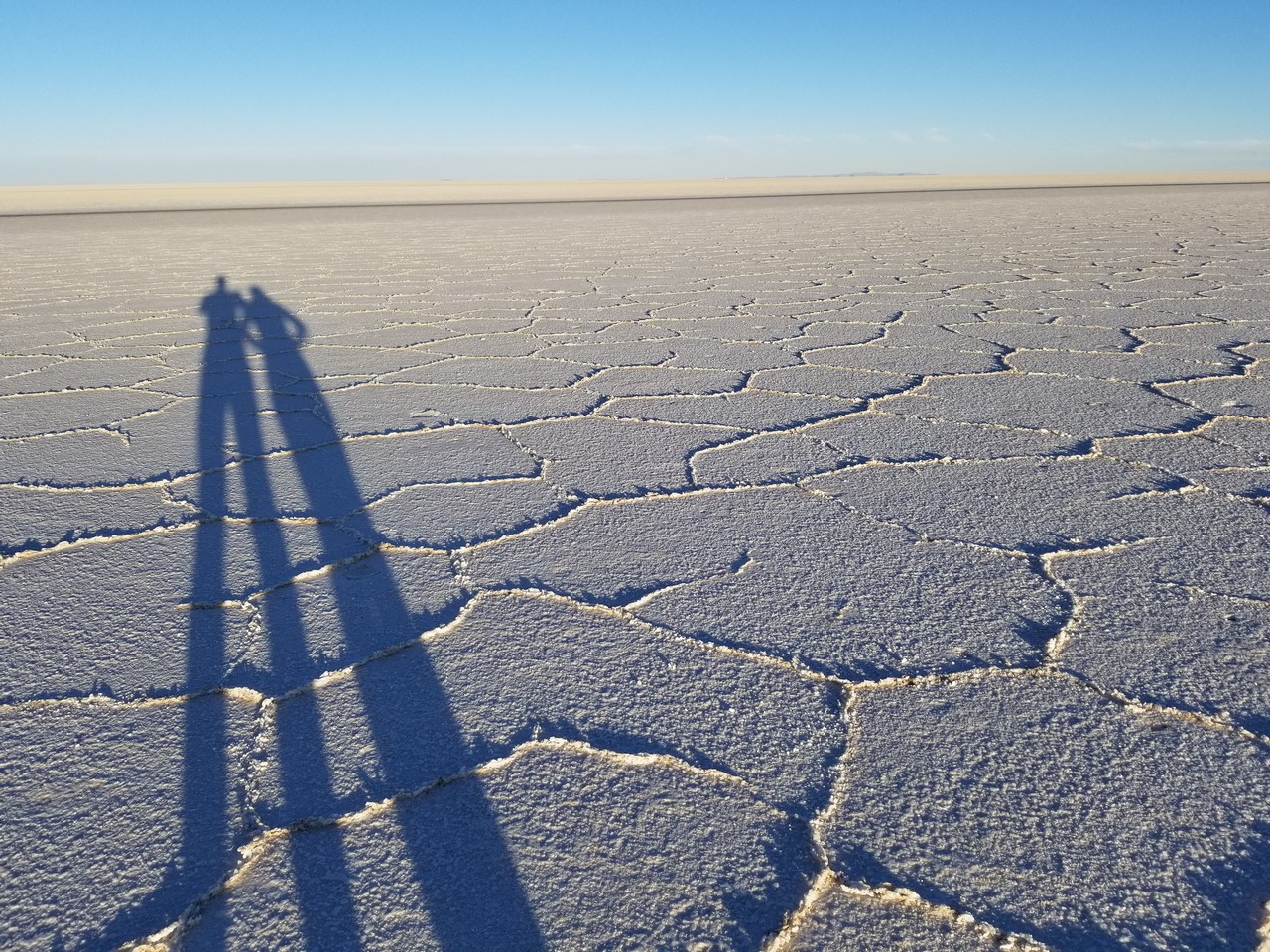 a shadow of two people on a flat surface