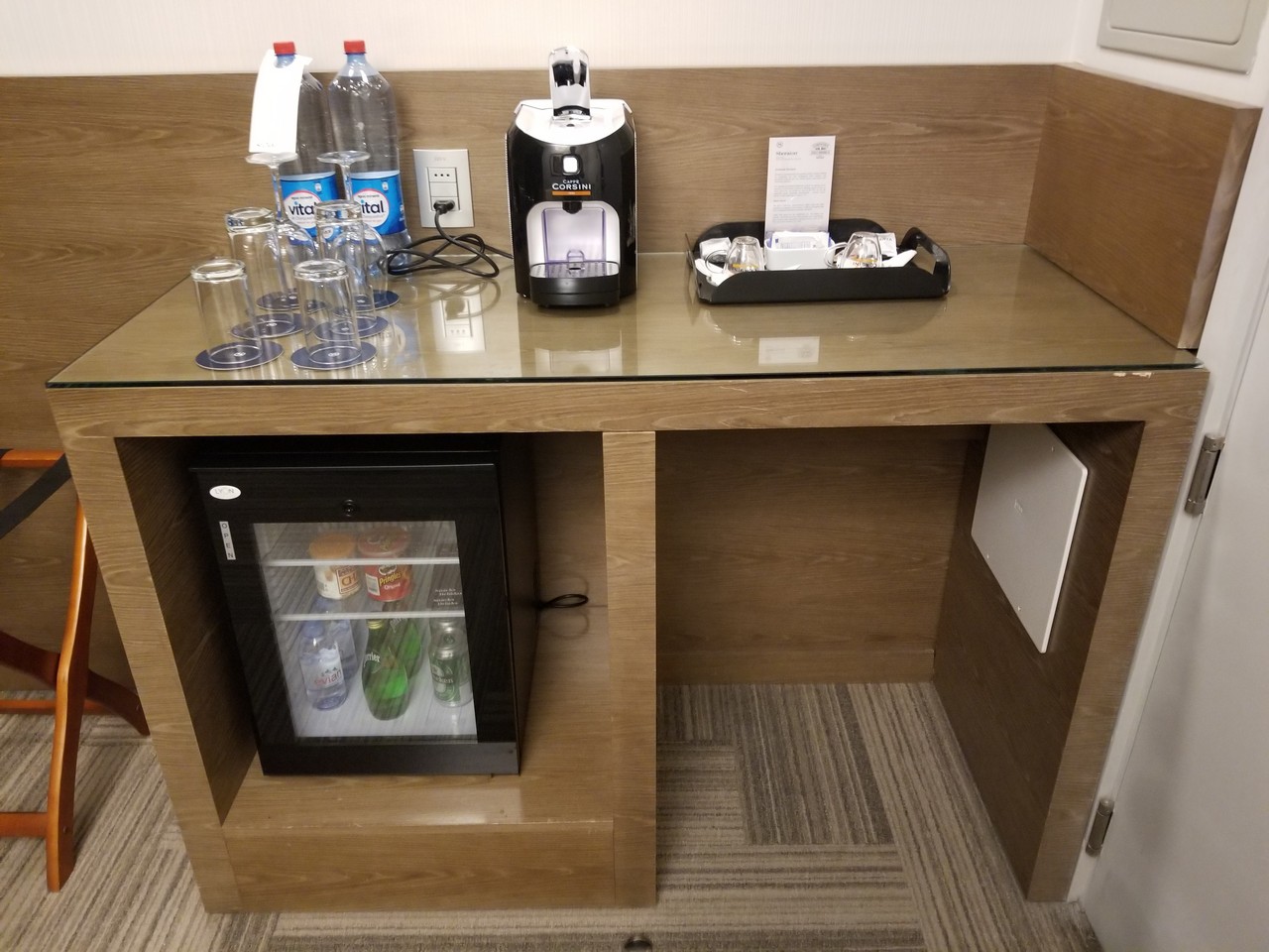 a table with a drink dispenser and a mini fridge