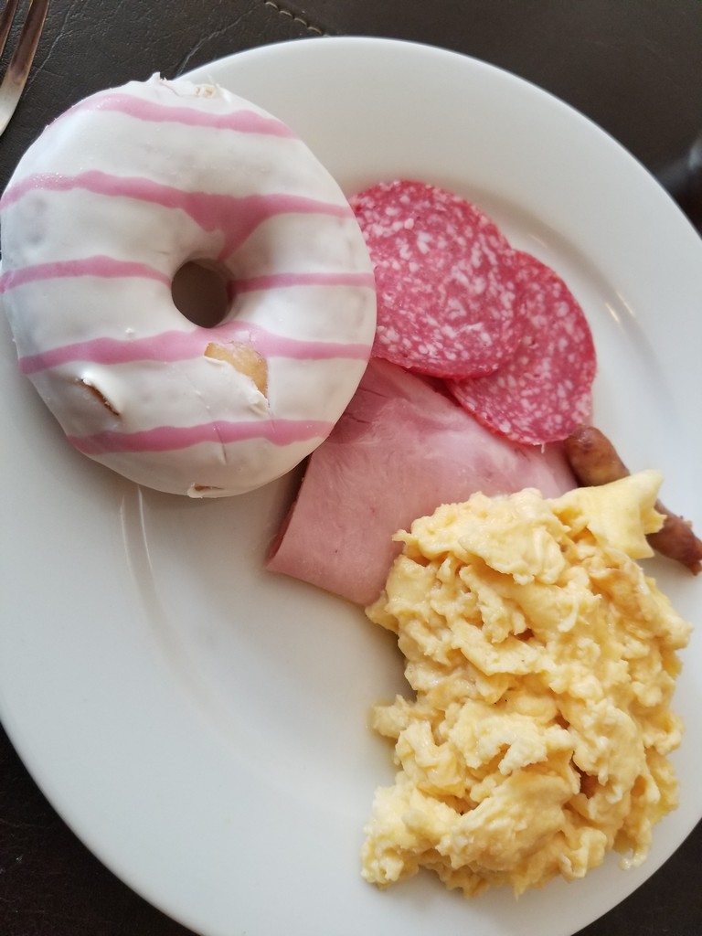 a plate of food with a donut and eggs