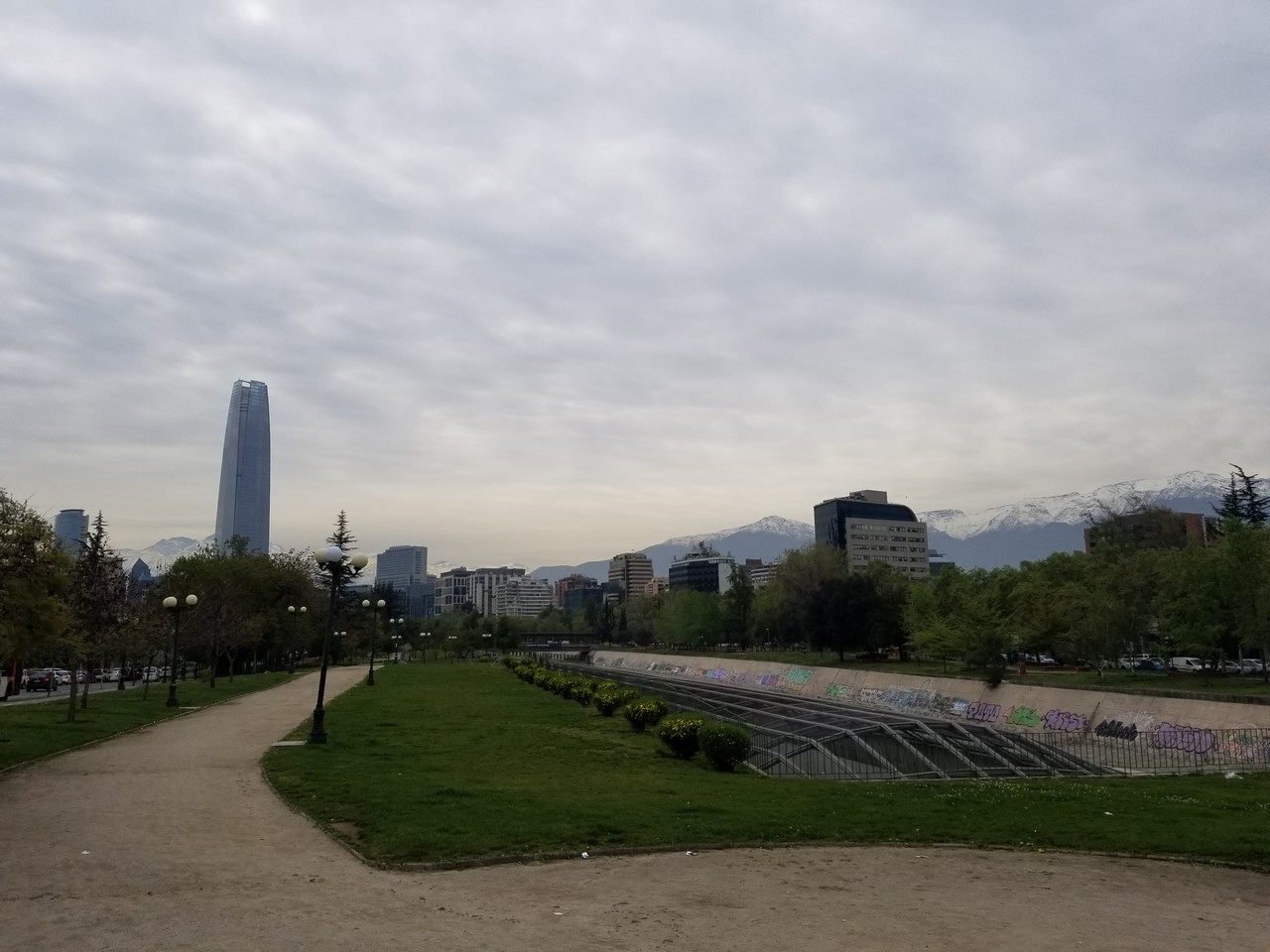 a path in a park with a city in the background