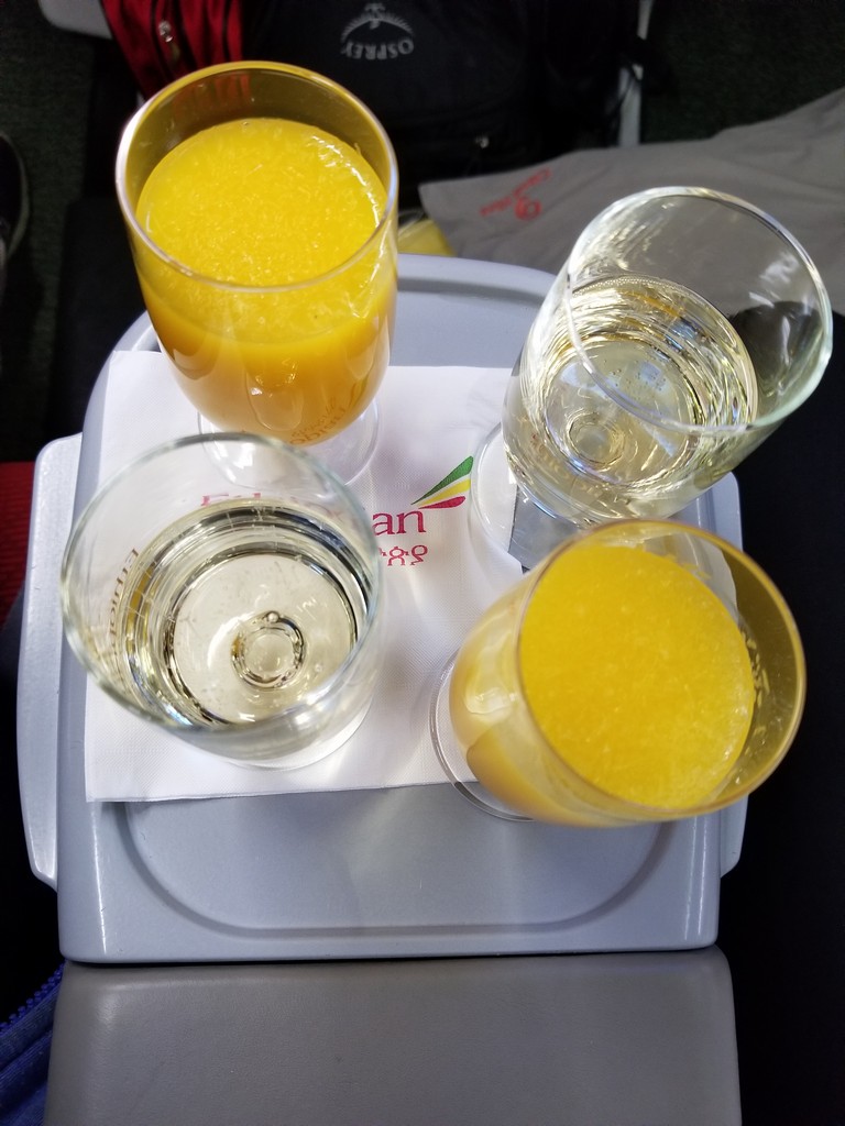 glasses of orange juice and a few glasses of liquid on a tray