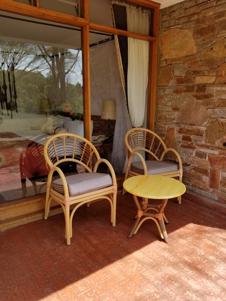 a wicker chairs and a table outside of a stone building