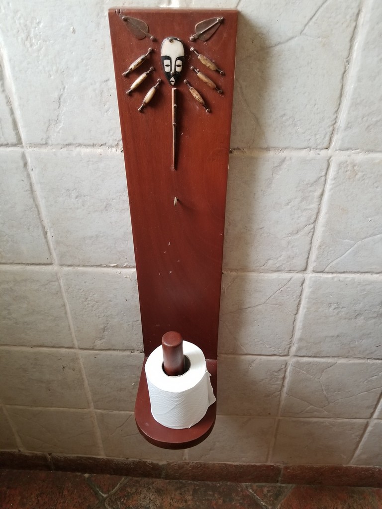 a toilet paper holder with a stick and a fish on it