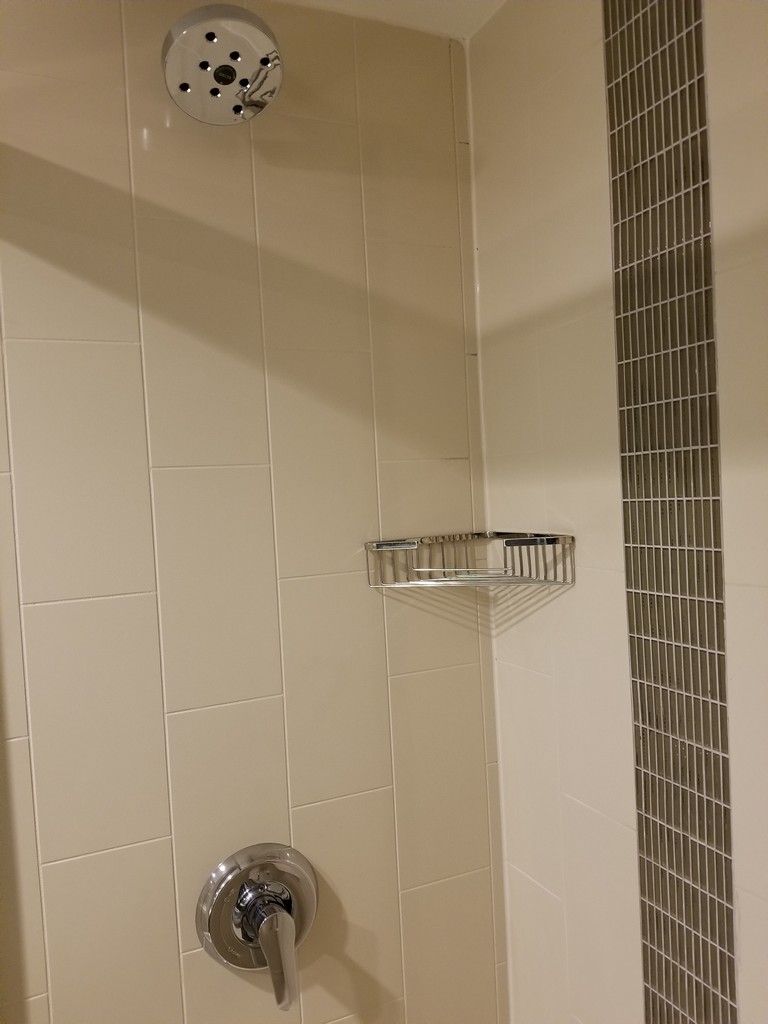 a shower with a metal shelf