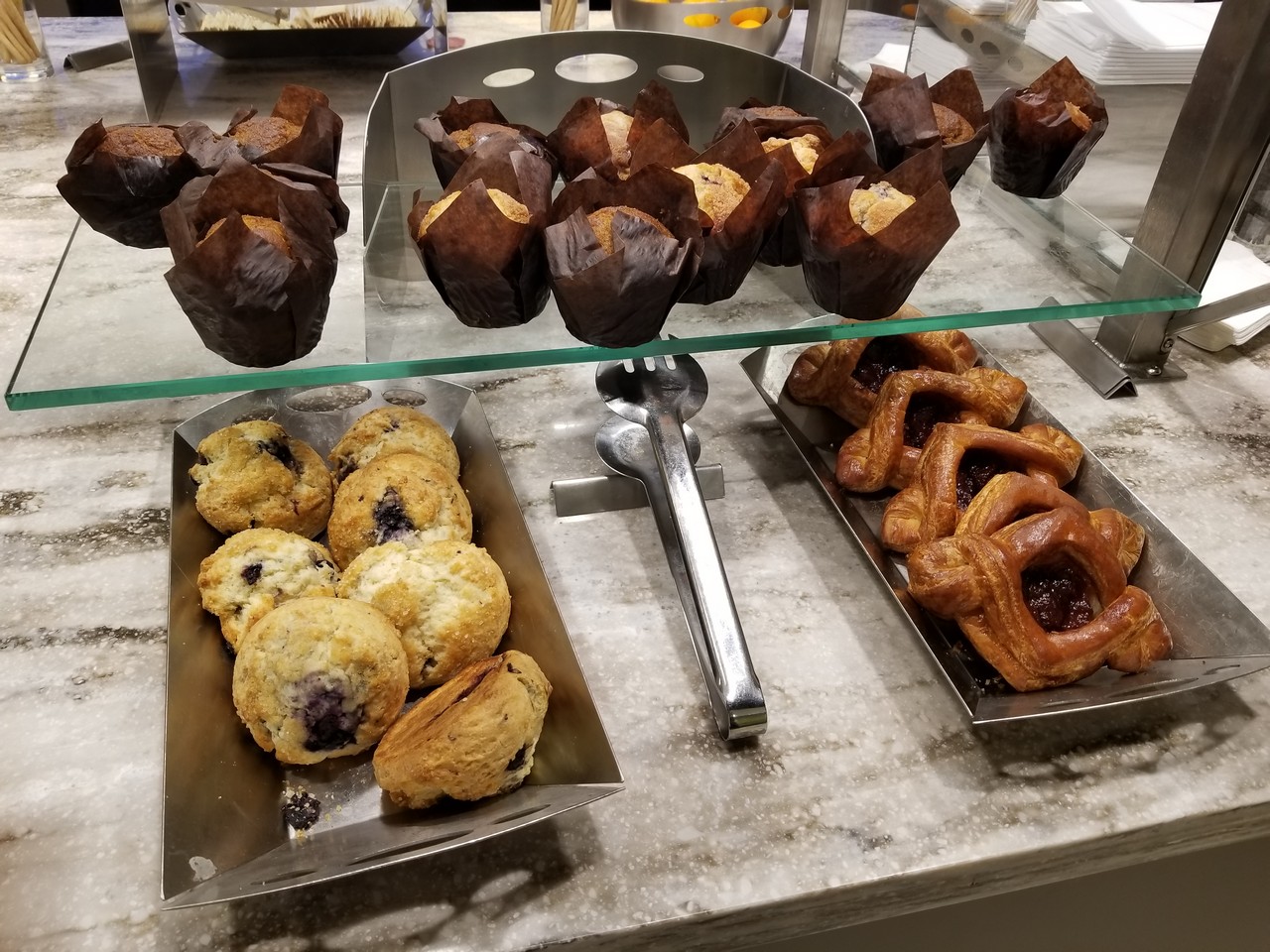 a tray of pastries and muffins on a counter