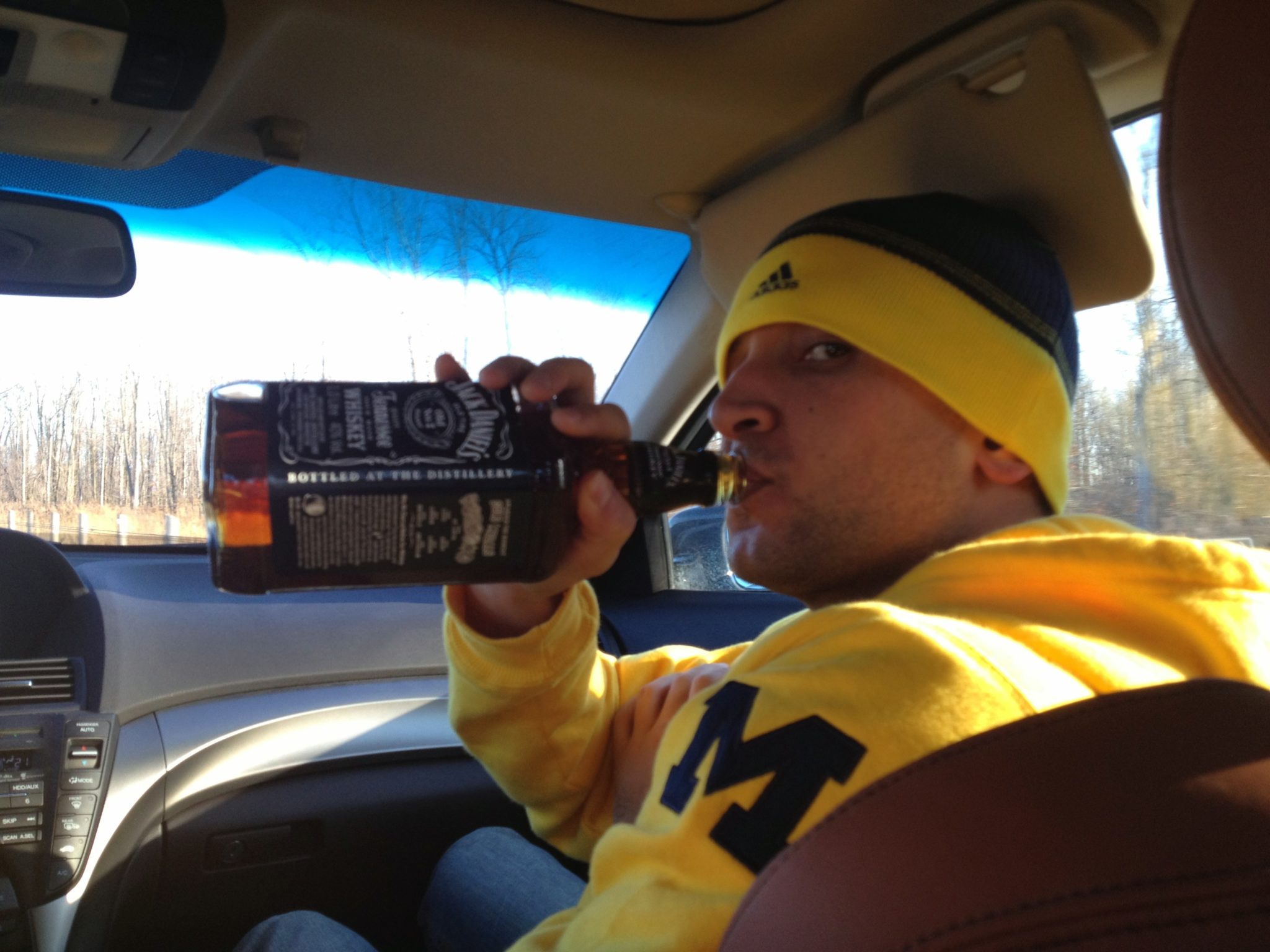 a man in a car drinking from a bottle