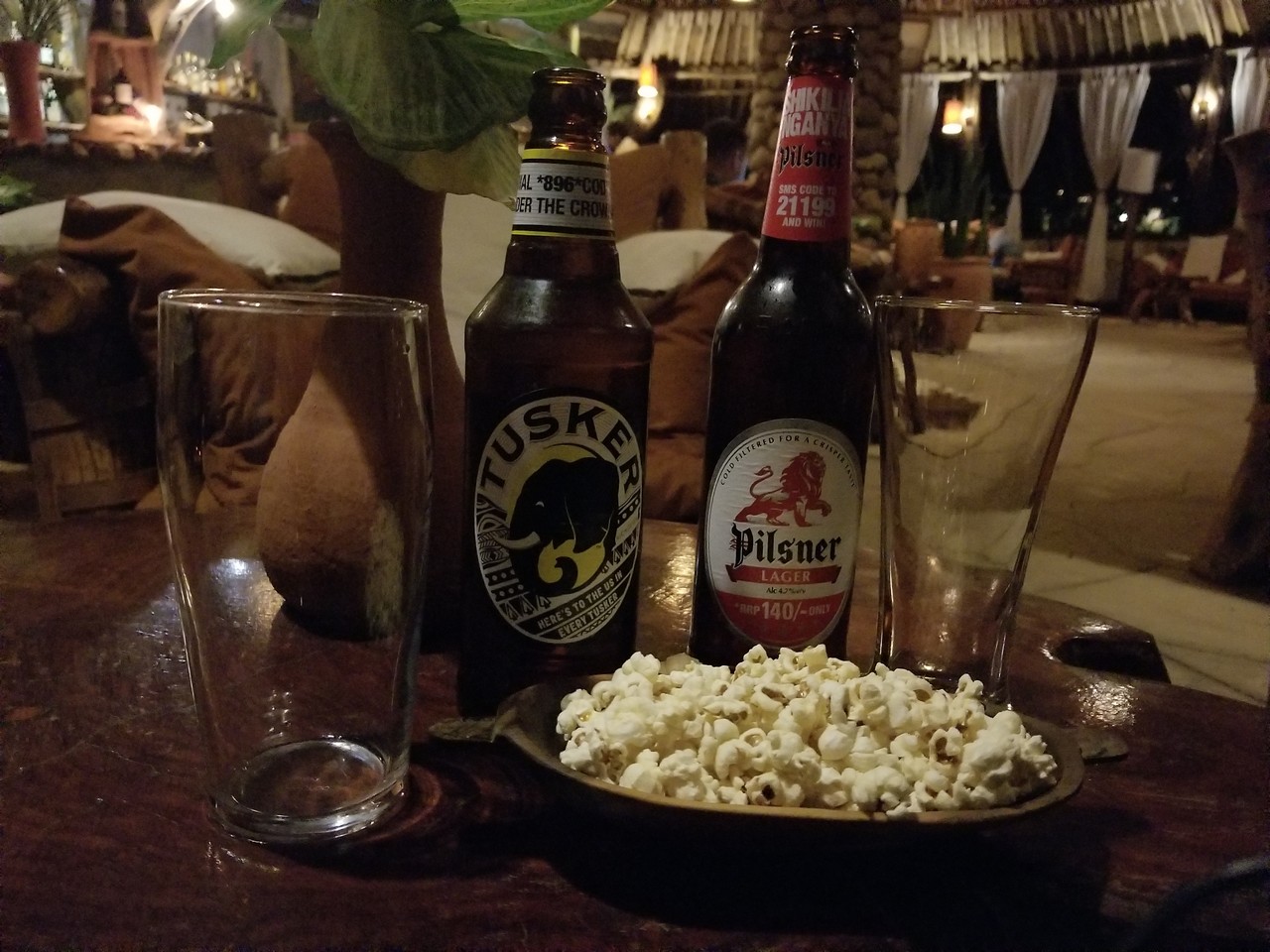 a plate of popcorn and bottles of beer on a table