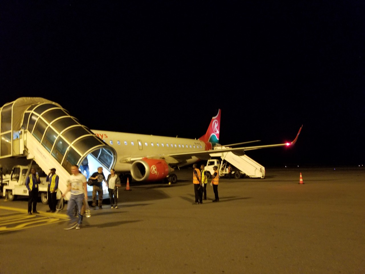 people boarding an airplane at night