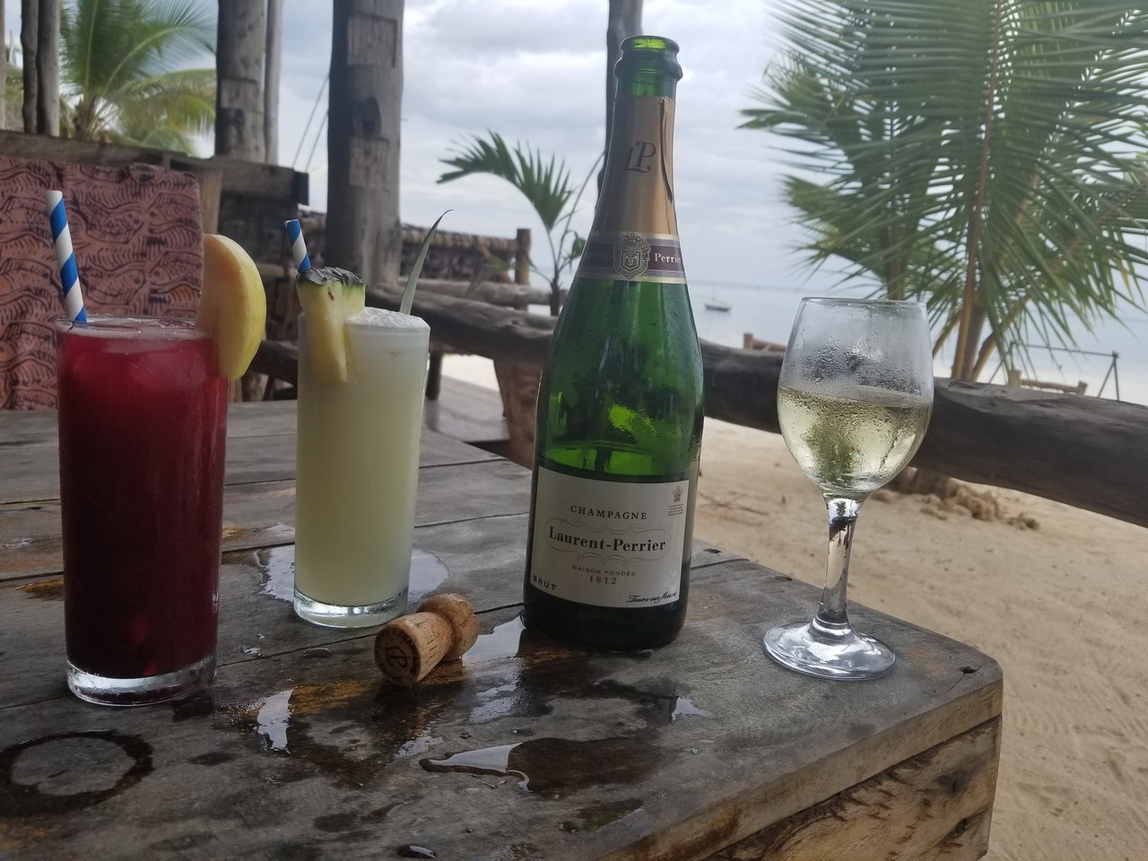 a bottle of champagne and two glasses of wine on a wooden table