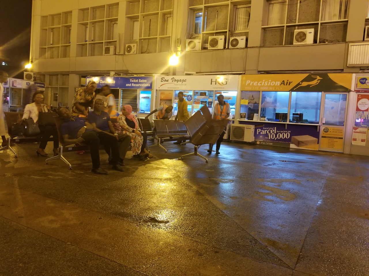 a group of people sitting on benches outside a building