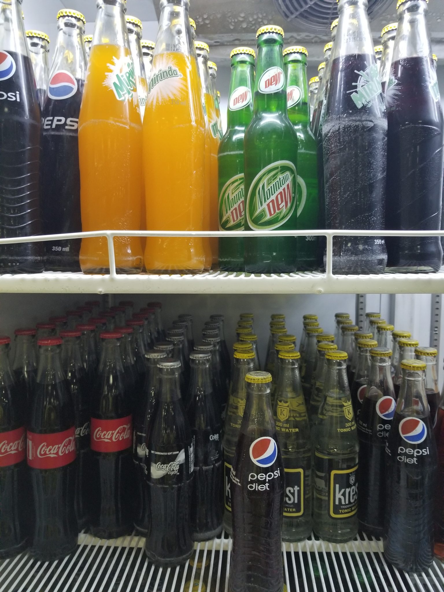 a shelf with bottles of soda